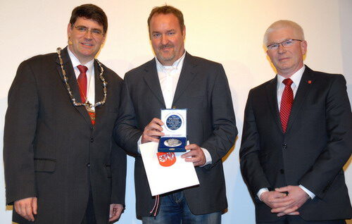 Bürgermeister Hans-Peter Haupt und der Vorsitzende des Ausschusses für Sport und Freizeit, Peter Nep, überreichten Udo Dehmel die Sportplakette.
