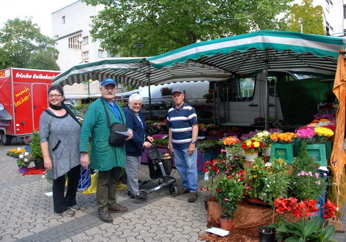 Marktmeister Ulrich Linke (2. v. lks.) und Marktbeschicker Robert Steur (r.) mit zwei Wesselinger Kundinnen am Blumenstand