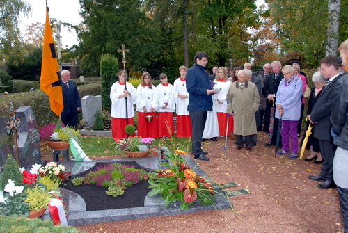 Bürgermeister Hans-Peter Haupt mit Bürgerinnen und Bürgern bei Gedenkfeier am Grab von Altbürgermeister Alfons Müller.