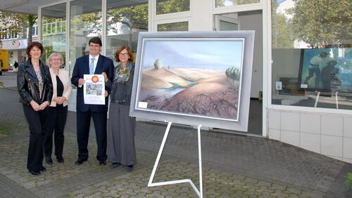 Bürgermeister Hans-Peter Haupt mit Rita Hamberger (li.), Ulrike Belling und Birgit Raabe (re.) neben Gemälde vor Ladenlokal am Alfons-Müller-Platz