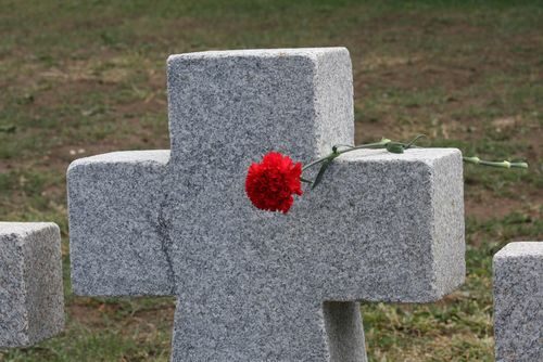 Steinkreuz mit roter Blume